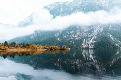 Scenic view of lake by snowcapped mountains against sky