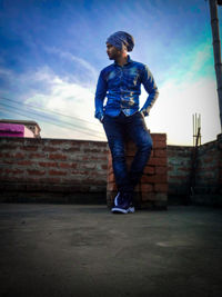 Full length of boy standing against the wall