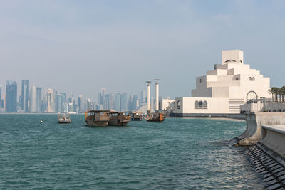 View of sea and cityscape against sky