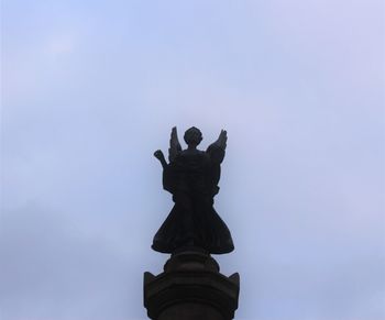 Low angle view of statue against blue sky