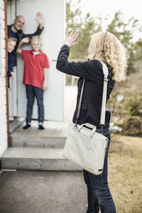 Woman waving goodbye to family