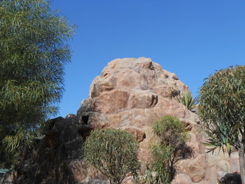 Low angle view of rock formation against clear blue sky