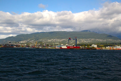 Scenic view of sea and cityscape against sky