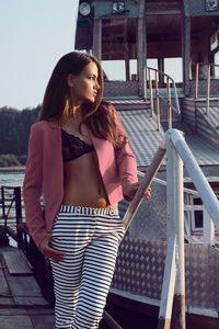 Sensuous woman standing on pier against boat