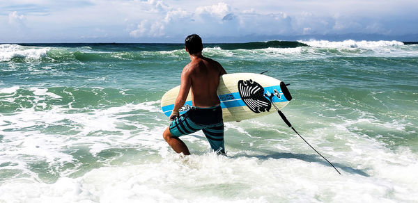 Rear view of shirtless man in sea