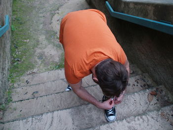 High angle view of man tying shoelace on steps