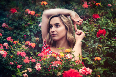 Portrait of beautiful young woman with red flowers