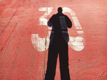 Shadow of man on number 30 at red footpath