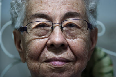 Close-up portrait of senior woman in eyeglasses at home