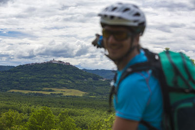 Portrait of man pointing at hill