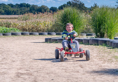 Happy child rides a pedal car around a track