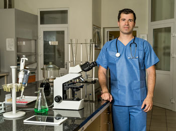 Portrait of young man standing at home