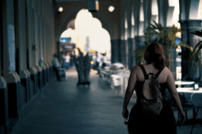 Rear view of women standing in corridor of building