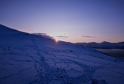 Scenic view of snow covered mountains against sky during sunset