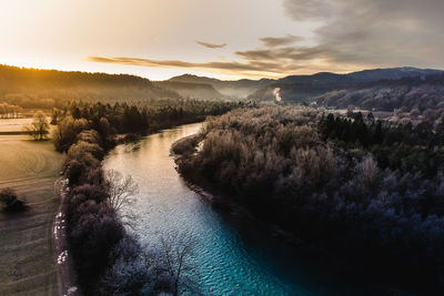 Scenic view of river against sky at sunset