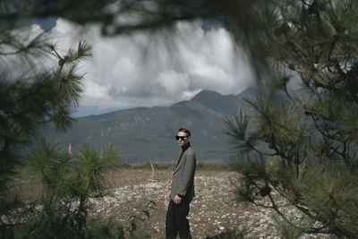 Man standing by tree on mountain