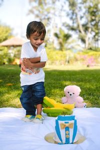 Side view of girl playing with toy on field
