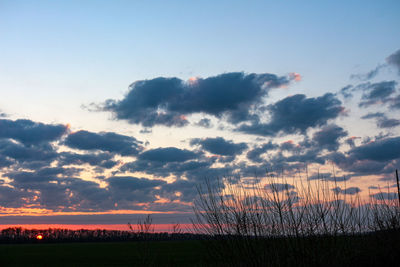 Scenic view of silhouette field against sky during sunset
