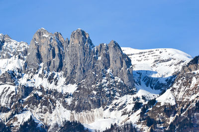 Panoramic view of snowcapped mountains against clear blue sky