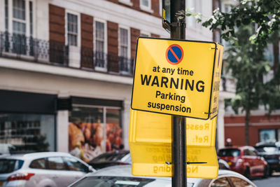 Yellow warning parking suspension sign on a residential street in london, uk.