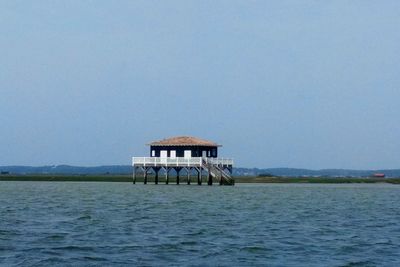 Lifeguard hut by sea against clear sky