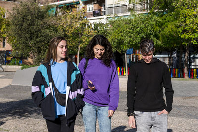 Young diverse friends walking outdoors on the street.