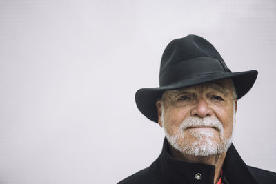 Portrait of confident man wearing hat against white background