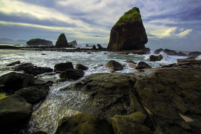 Rocks on beach against sky