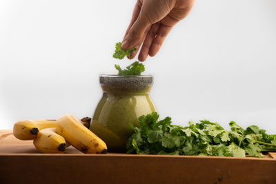 Cropped image of person preparing food against white background