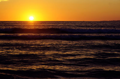 Scenic view of sea against orange sky