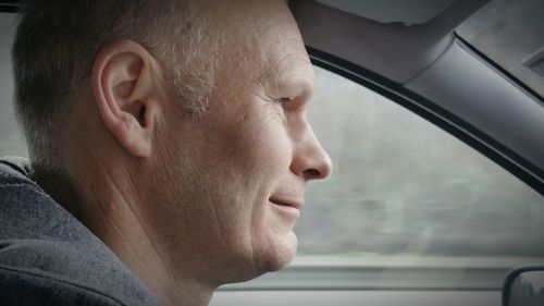 Close-up of mid adult man driving car