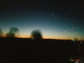 Silhouette trees against sky at night