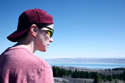 Close-up of young man wearing sunglasses while looking at view