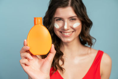 Portrait of smiling woman holding bottle