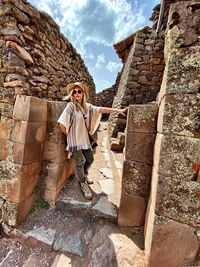 Full length of man standing against brick wall