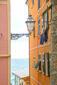 Close-up of yellow hanging by building against sky