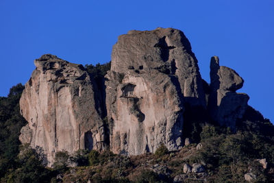 Low angle view of rocks against blue sky