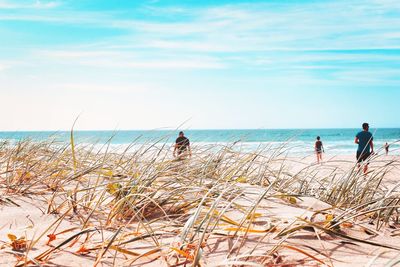 People on beach against sky