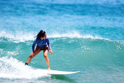 Full length of woman surfing in sea