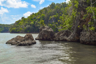 Scenic view of rock formation in sea against sky