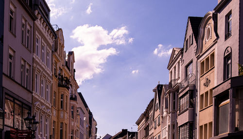 Low angle view of buildings in town against sky