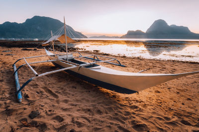 Boat moored at beach against sky