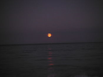 Scenic view of sea against clear sky at night