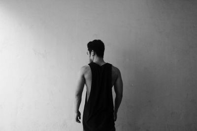 Rear view of a man standing on floor