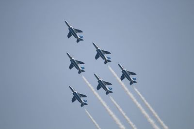 Low angle view of airshow against clear sky