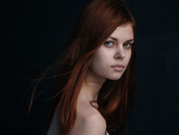 Portrait of a beautiful young woman over black background