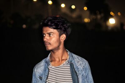 Young man looking away at night