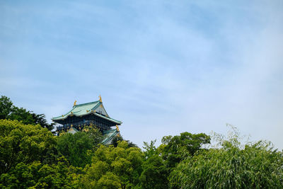 Low angle view of historic castle by trees against sky