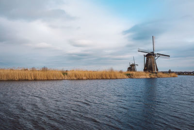 Traditional windmill on land against sky
