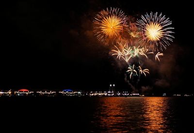 Firework display over river at night